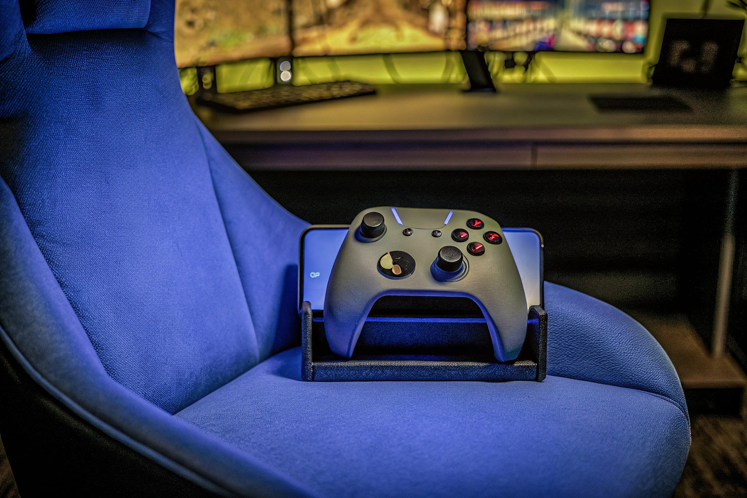 Cable Guys Ikon im Gaming-Setup, hält einen Controller und ein Smartphone. Cable Guys Ikon im Einsatz