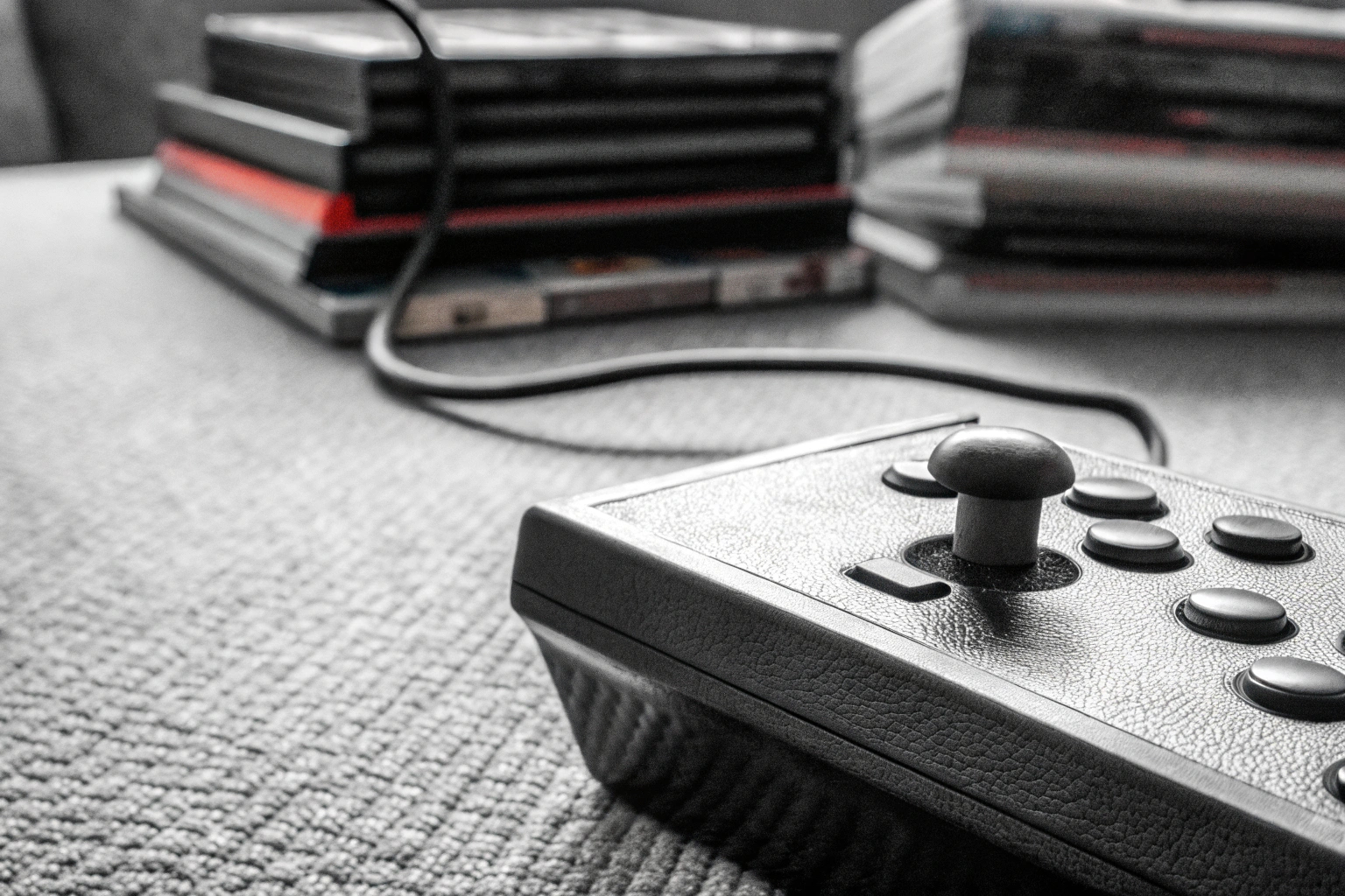 Detailaufnahme einer klassischen Retro-Konsole mit einem Stapel alter Spielekassetten daneben. Retro-Konsole mit Spielekassetten