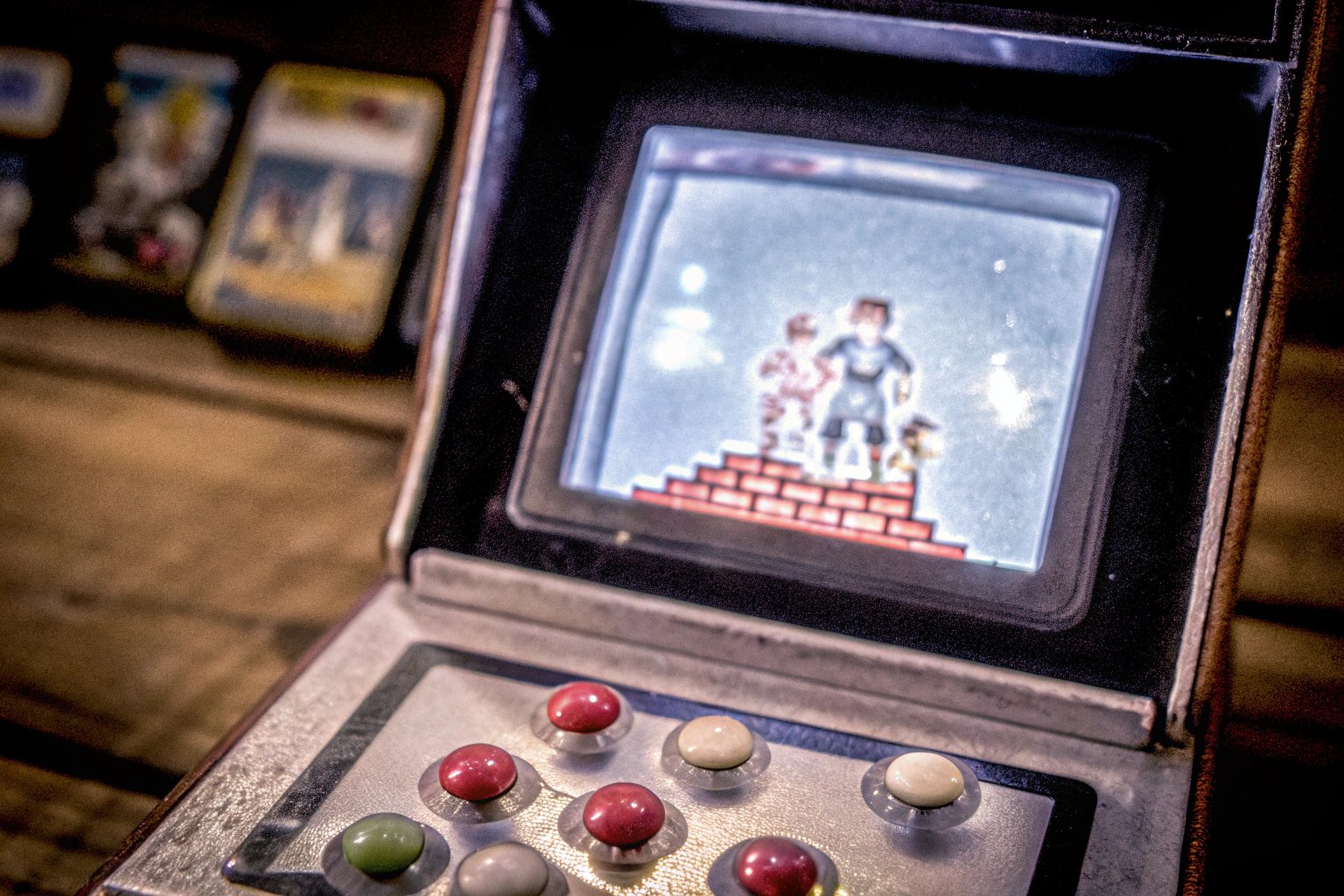 Detailaufnahme einer Mini-Arcademachine mit einem klassischen Retro-Spiel auf dem Bildschirm. Mini-Arcademachine Retro Spiel