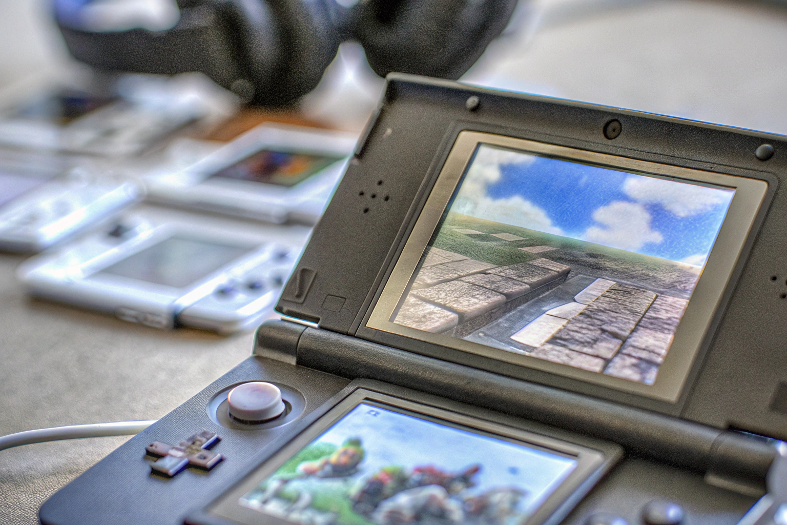 Detailaufnahme einer Nintendo 3DS-Konsole mit verschiedenen beliebten Spielen und Zubehör. Nintendo 3DS Konsole mit Spielen