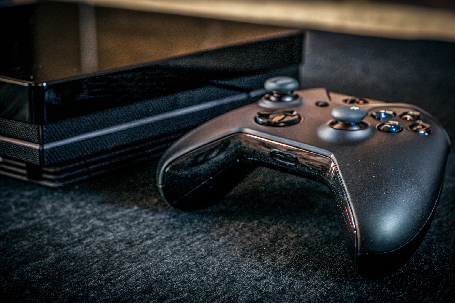 Detailaufnahme einer Spielekonsole mit einem Controller daneben, perfekt für Konsolenspiele. Spielekonsole mit Controller