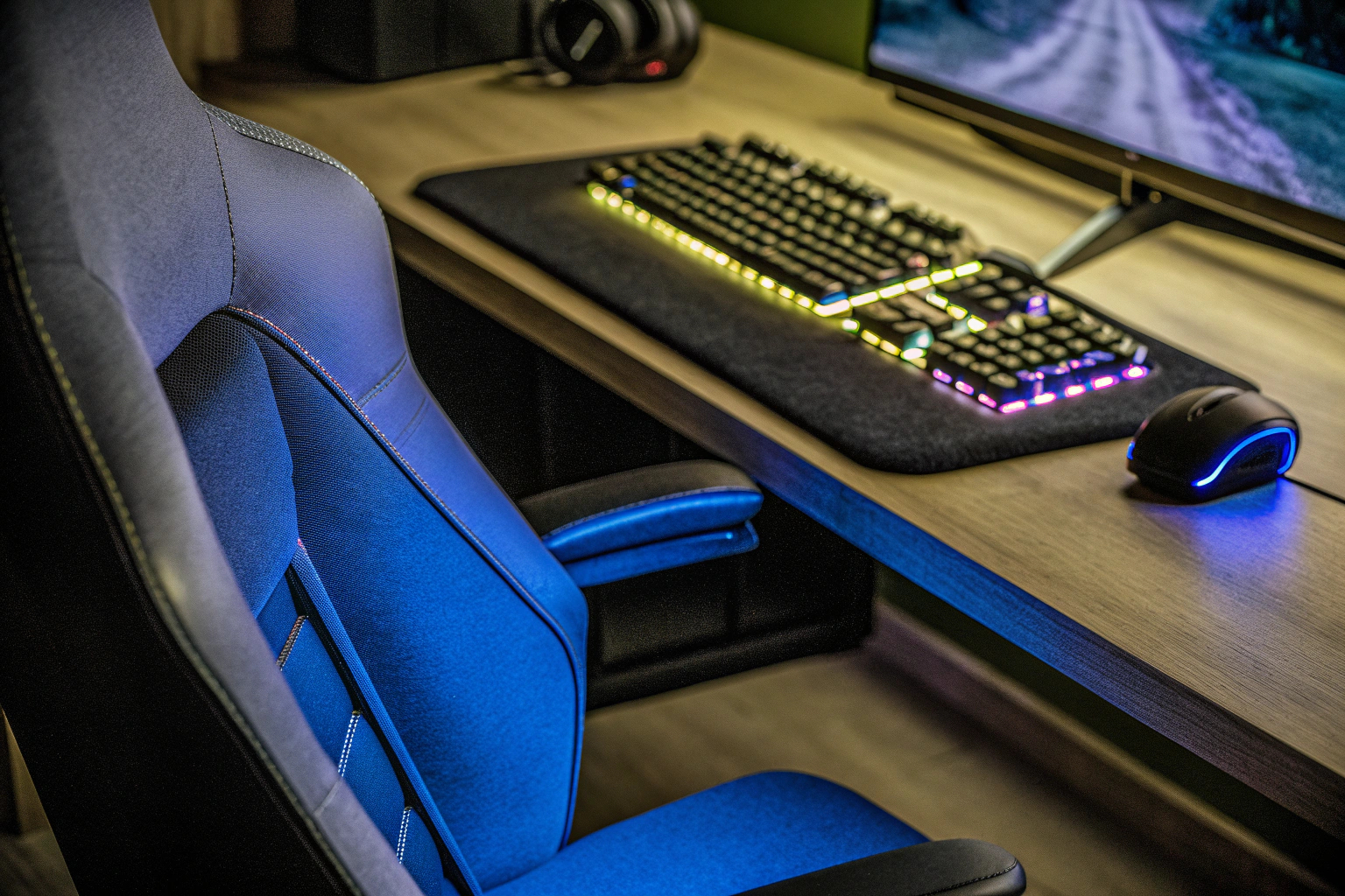 Detailaufnahme eines Gaming-Setups mit RGB-Beleuchtung und ergonomischem Stuhl. Gaming-Setup mit RGB-Beleuchtung