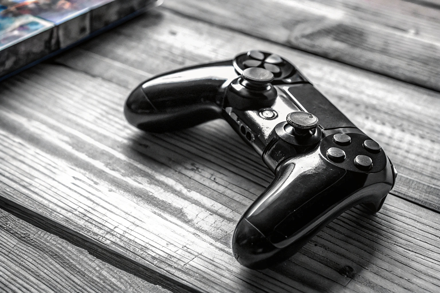 Detailaufnahme eines PlayStation 4 Pro Controllers auf einem Holztisch. PlayStation 4 Pro Controller