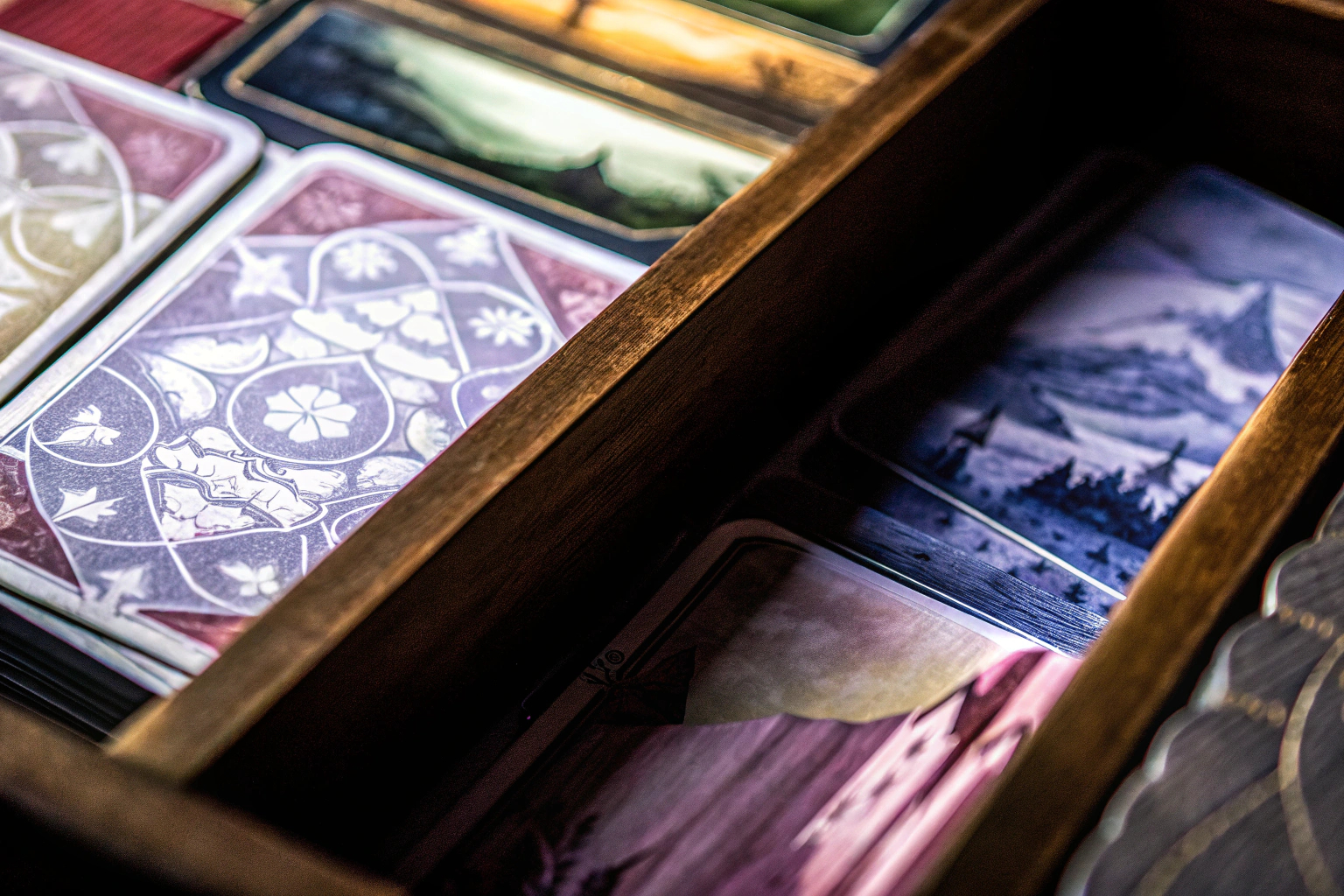 Detailaufnahme von farbenfrohen Artefakten und Spielkarten aus der Vale of Eternity: Artefakte-Erweiterung. Vale of Eternity: Artefakte-Erweiterung