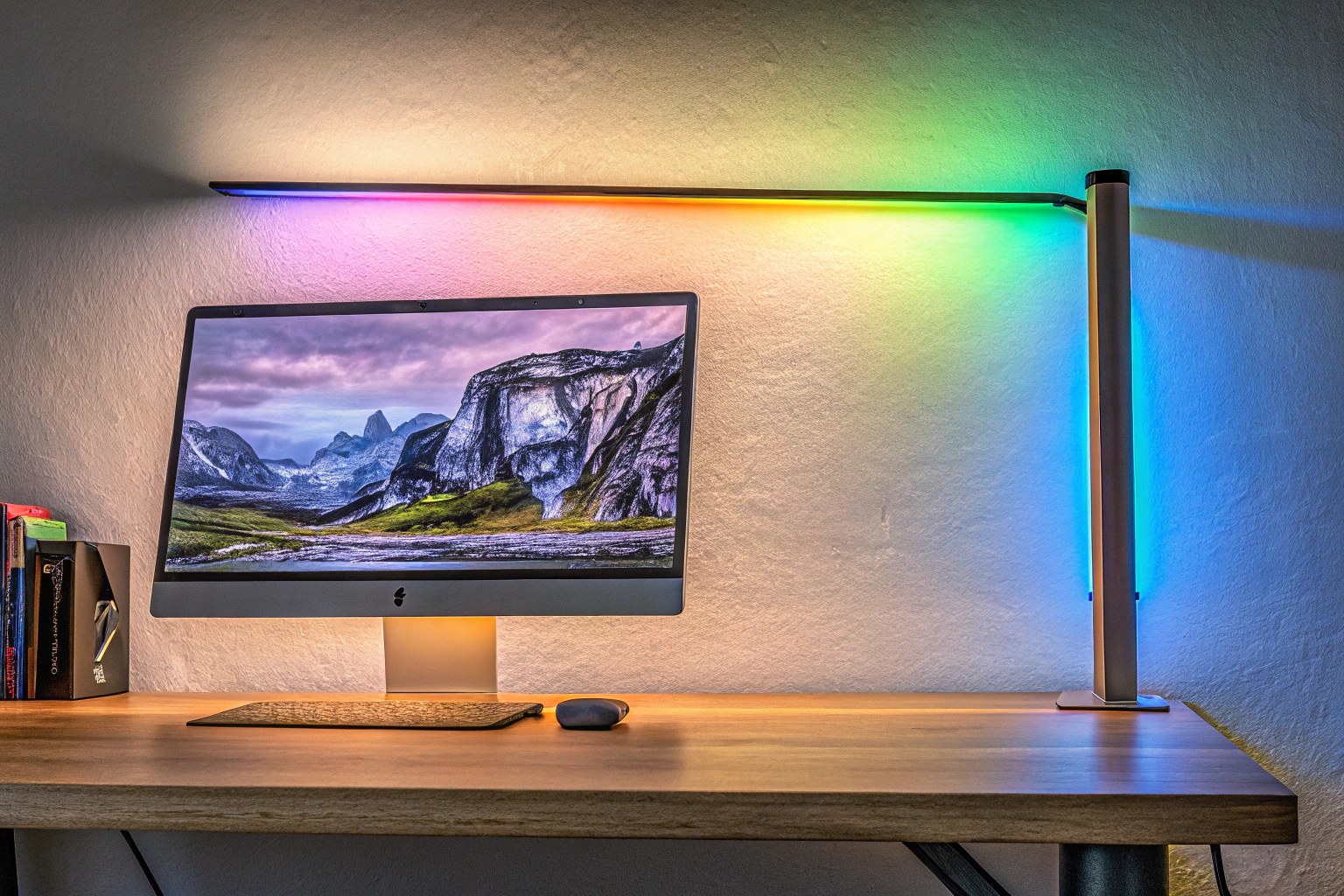Die Quntis Computer Monitor Lampe auf einem Schreibtisch, beleuchtet in verschiedenen RGB-Farben. Quntis Computer Monitor Lampe