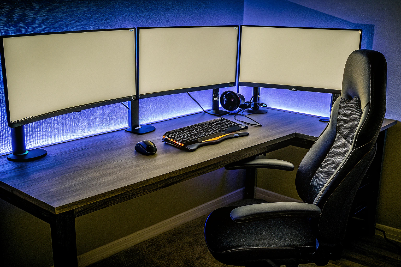 Ein aufgeräumter Schreibtisch mit mehreren Bildschirmen und Gaming-Zubehör, der zeigt, wie ein komplettes Setup aussehen kann. Komplettes Gaming-Setup