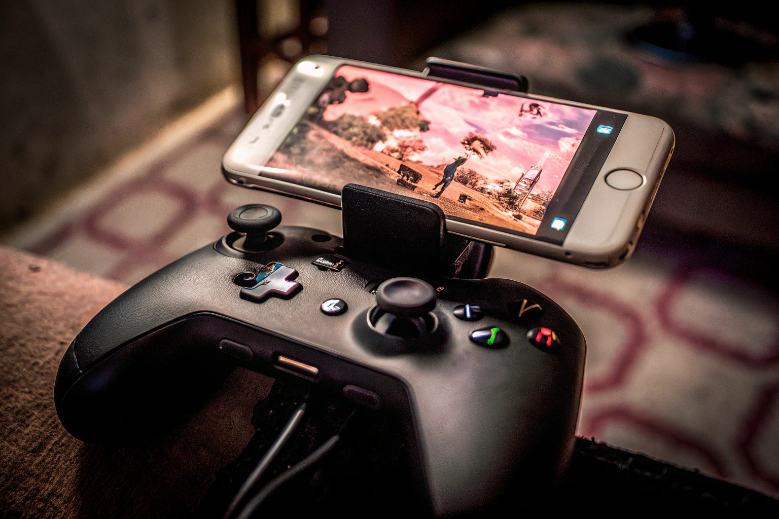 Ein Bild von einem Gamer, der ein Mobiltelefon mit einem Controller benutzt. Gamer mit mobilem Controller