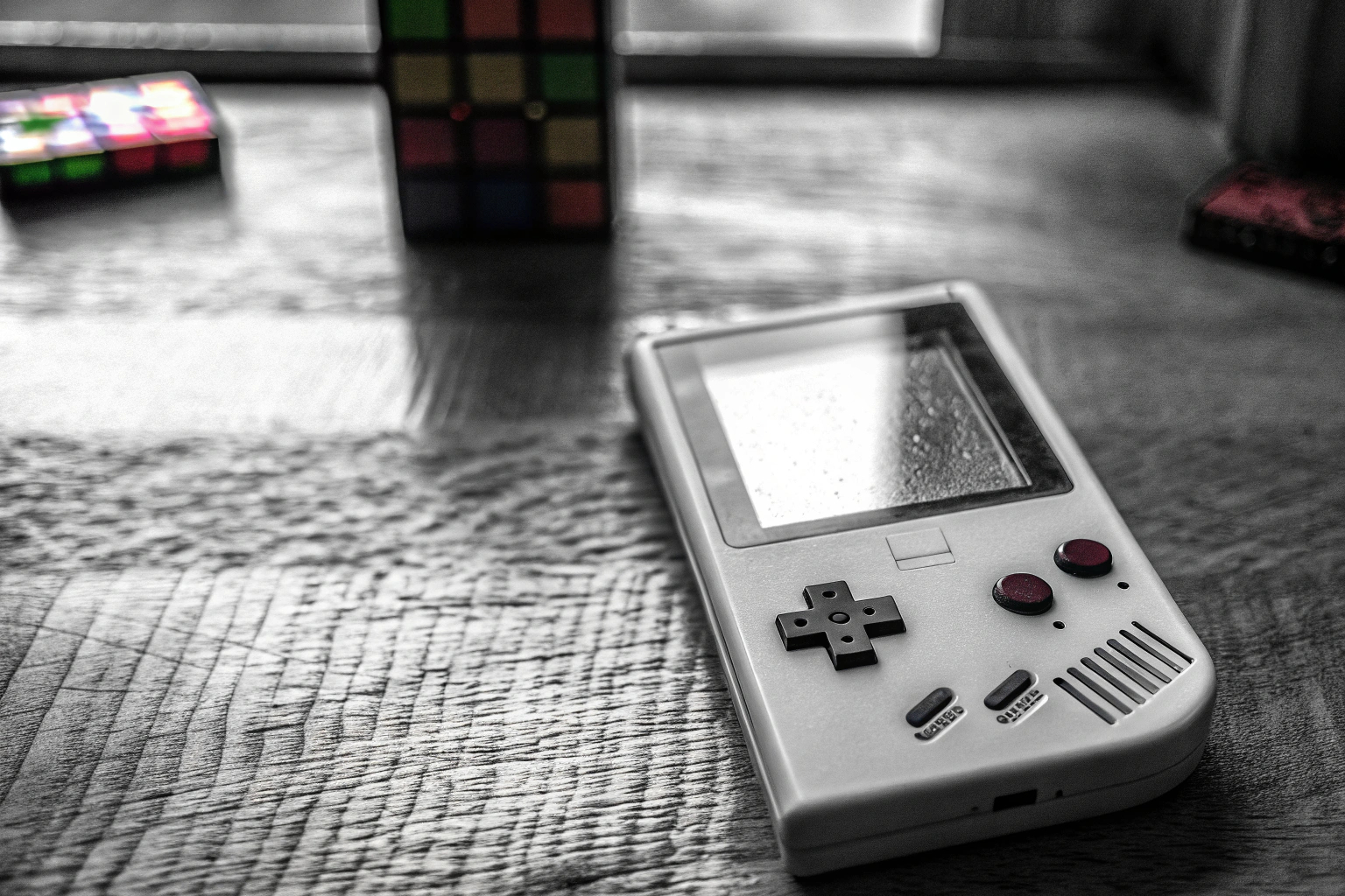 Ein Game Boy mit dem Spiel Tetris im Hintergrund. Game Boy mit Tetris