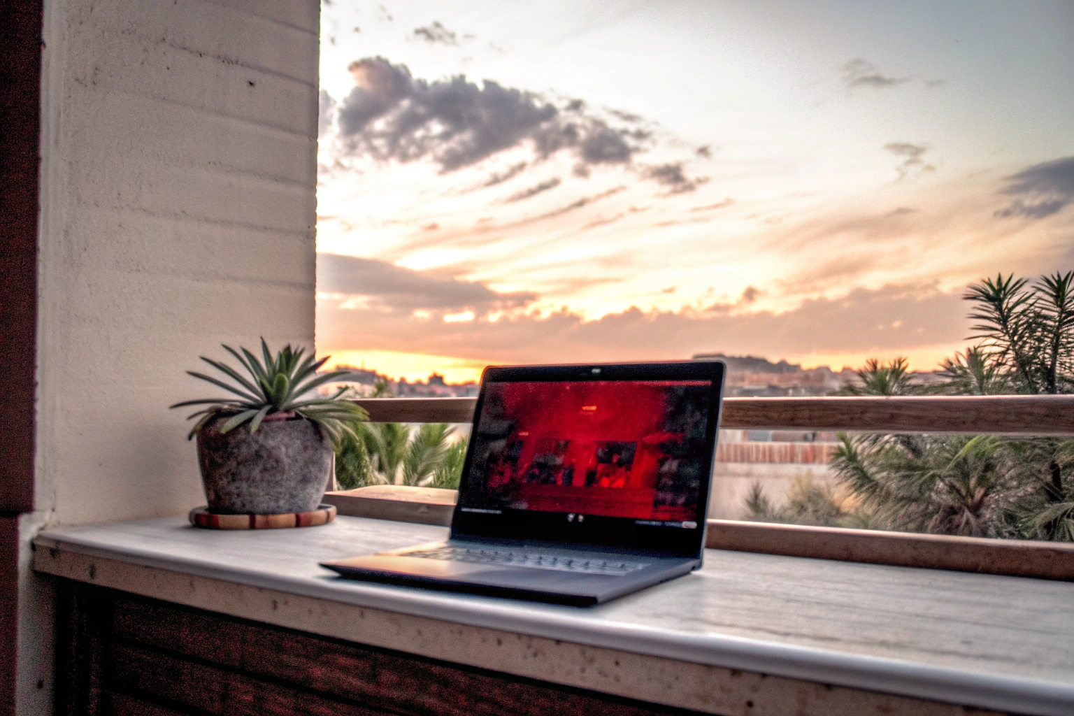 Ein Gamer, der auf einem Laptop ein Cloud-Gaming-Spiel spielt, während er auf einem Balkon sitzt. Gamer spielt Cloud-Gaming auf einem Laptop