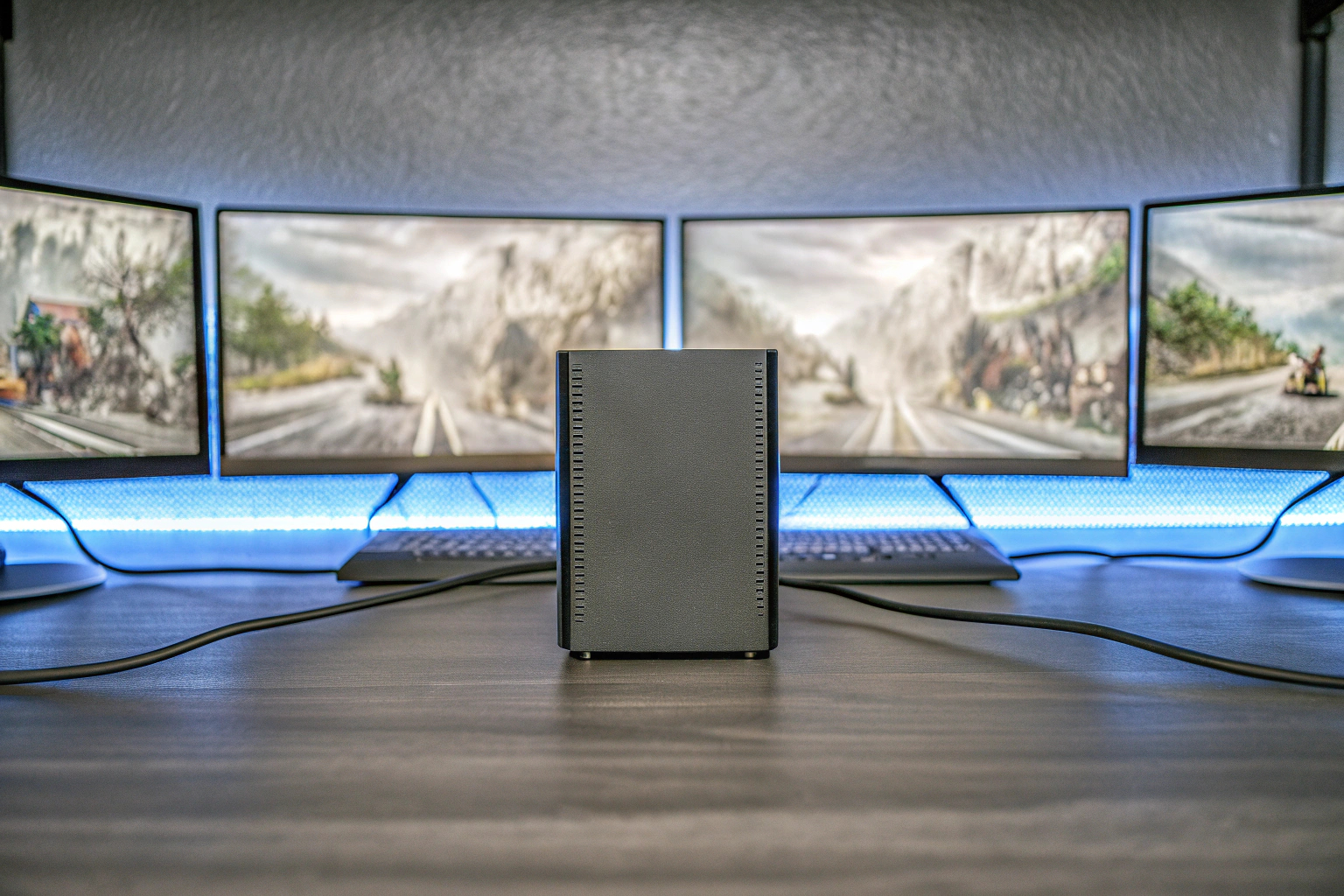 Ein Gamer, der auf einem Mini-PC spielt, umgeben von mehreren Monitoren. Gaming mit Mini-PC