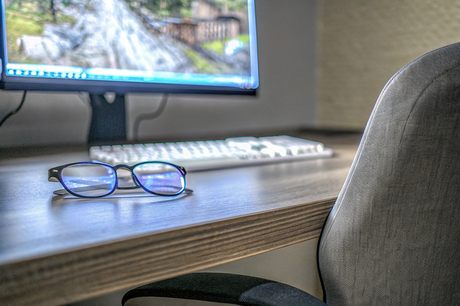 Ein Gamer, der mit einer Blaulichtfilter-Brille vor einem Bildschirm sitzt, um seine Augen zu schützen. Gamer mit Blaulichtfilter-Brille