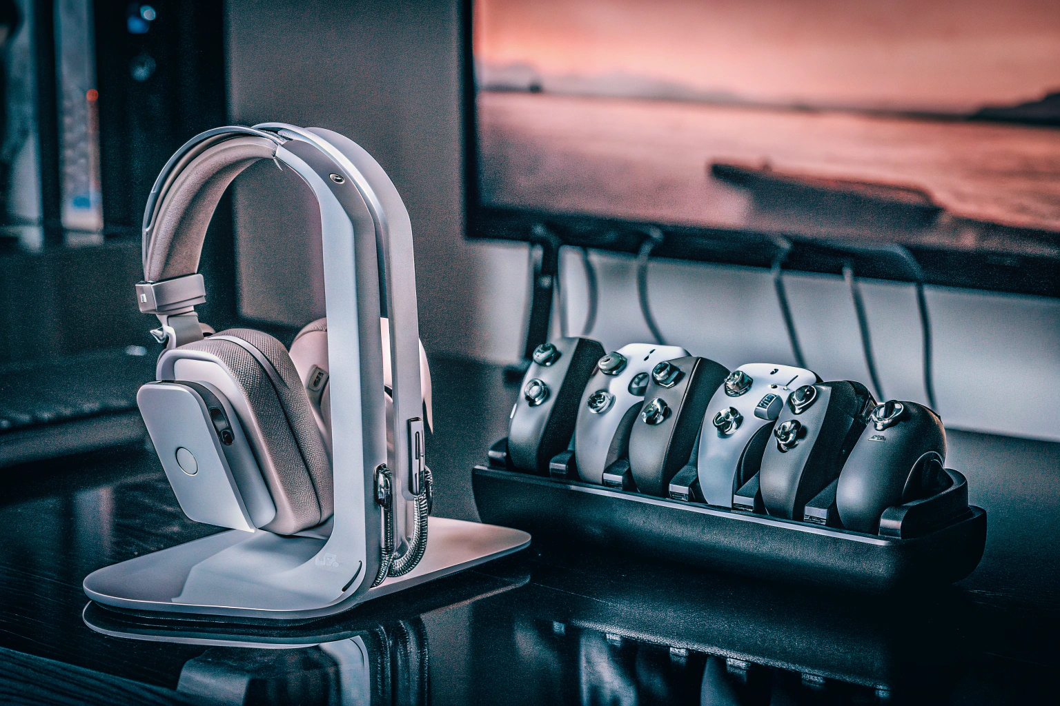 Ein gut organisiertes Gaming-Setup mit einem Headset-Ständer und ordentlich verstaute Controller. Gaming-Setup mit Headset-Ständer