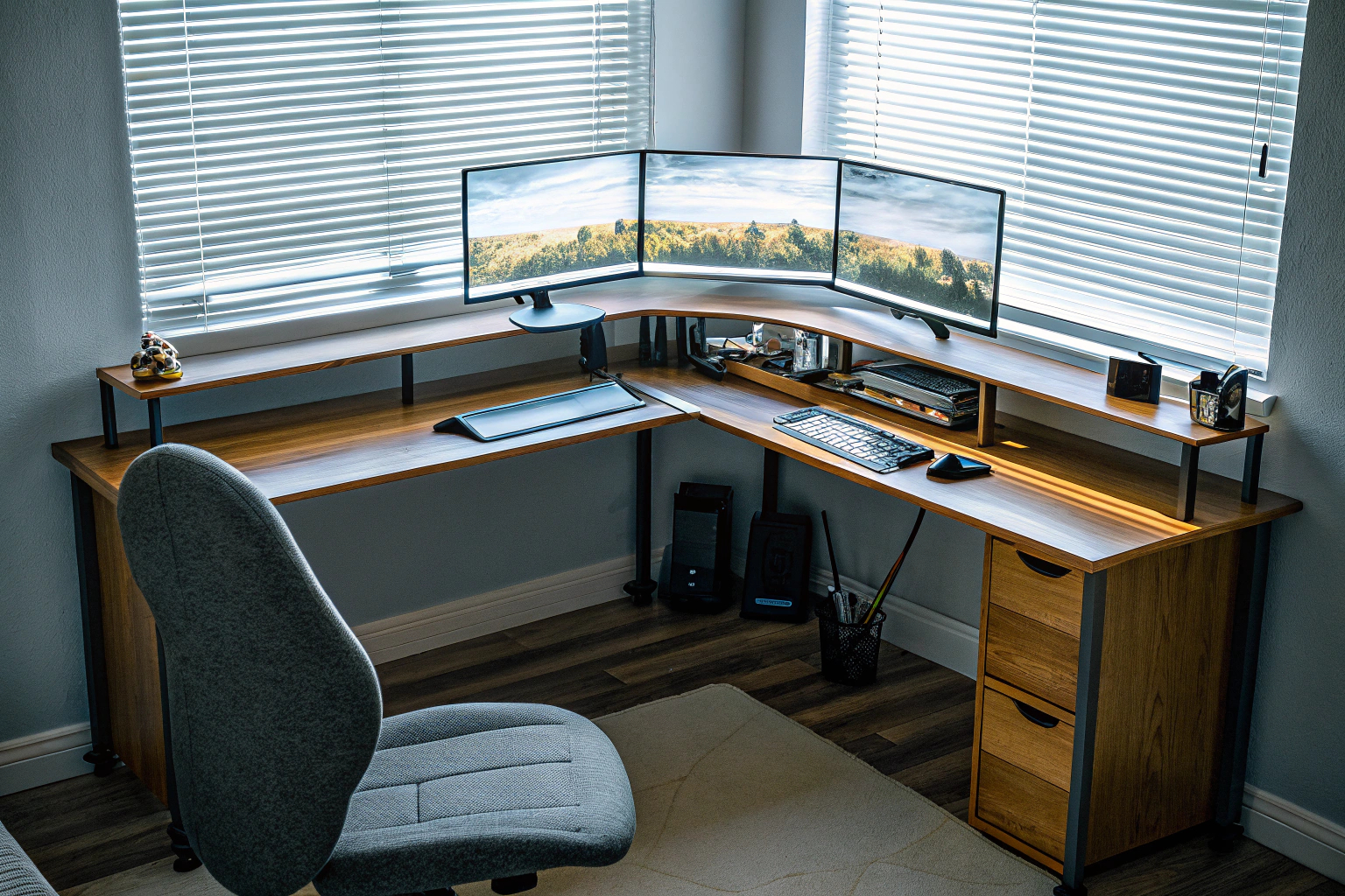 Ein L-förmiger Schreibtisch mit viel Stauraum und mehreren Monitoren für ein produktives Homeoffice. L-förmiger Schreibtisch mit Stauraum