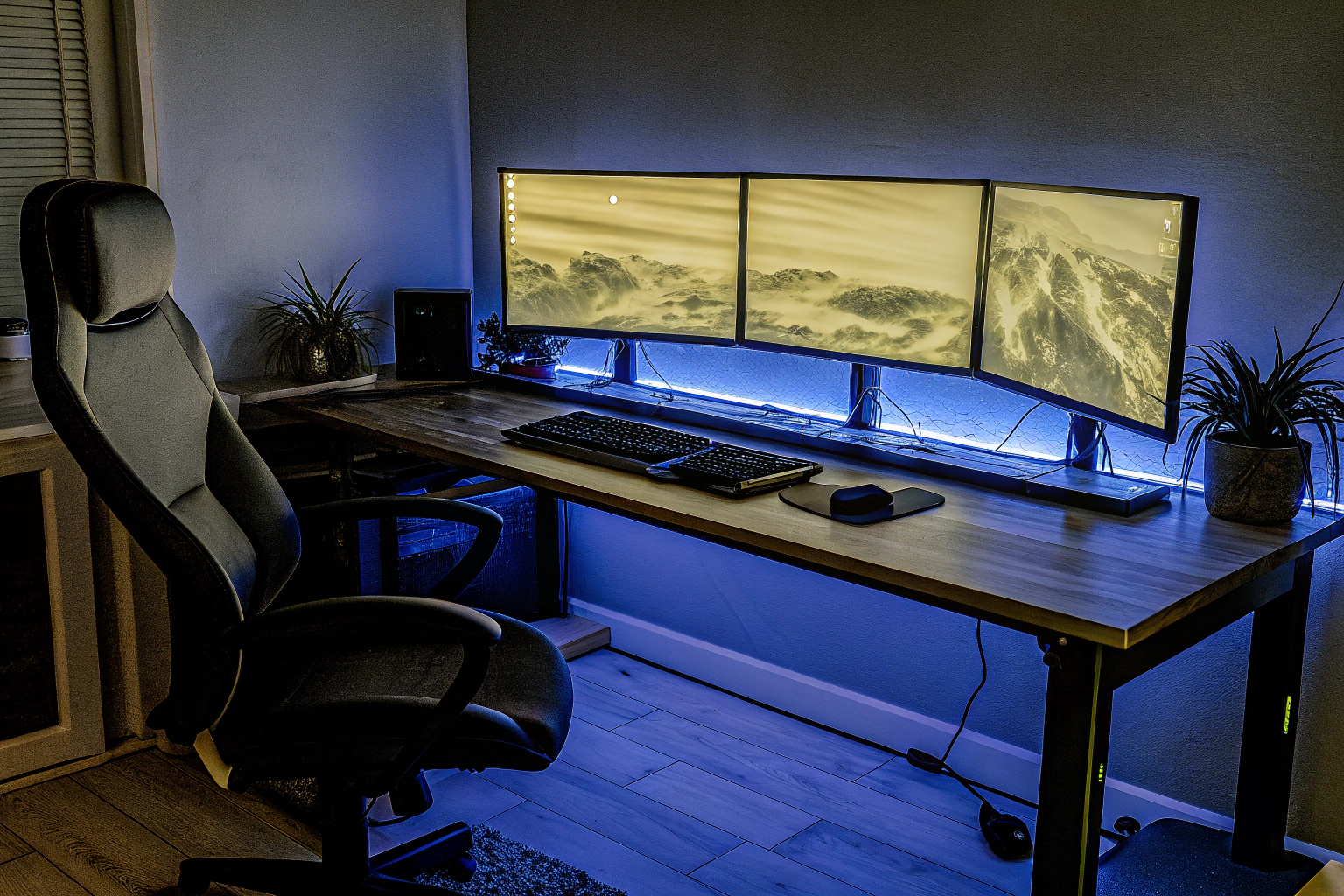 Ein moderner Gaming-Schreibtisch in einem Homeoffice mit LED-Beleuchtung und mehreren Monitoren. Moderner Gaming-Schreibtisch mit LED-Beleuchtung