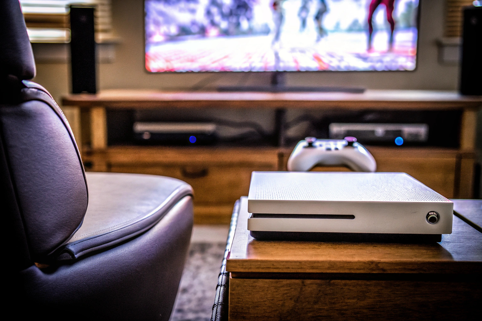 Ein moderner Gaming-Setup mit einer Konsole, einem großen Fernseher und einem komfortablen Gaming-Stuhl. Modernes Gaming-Setup