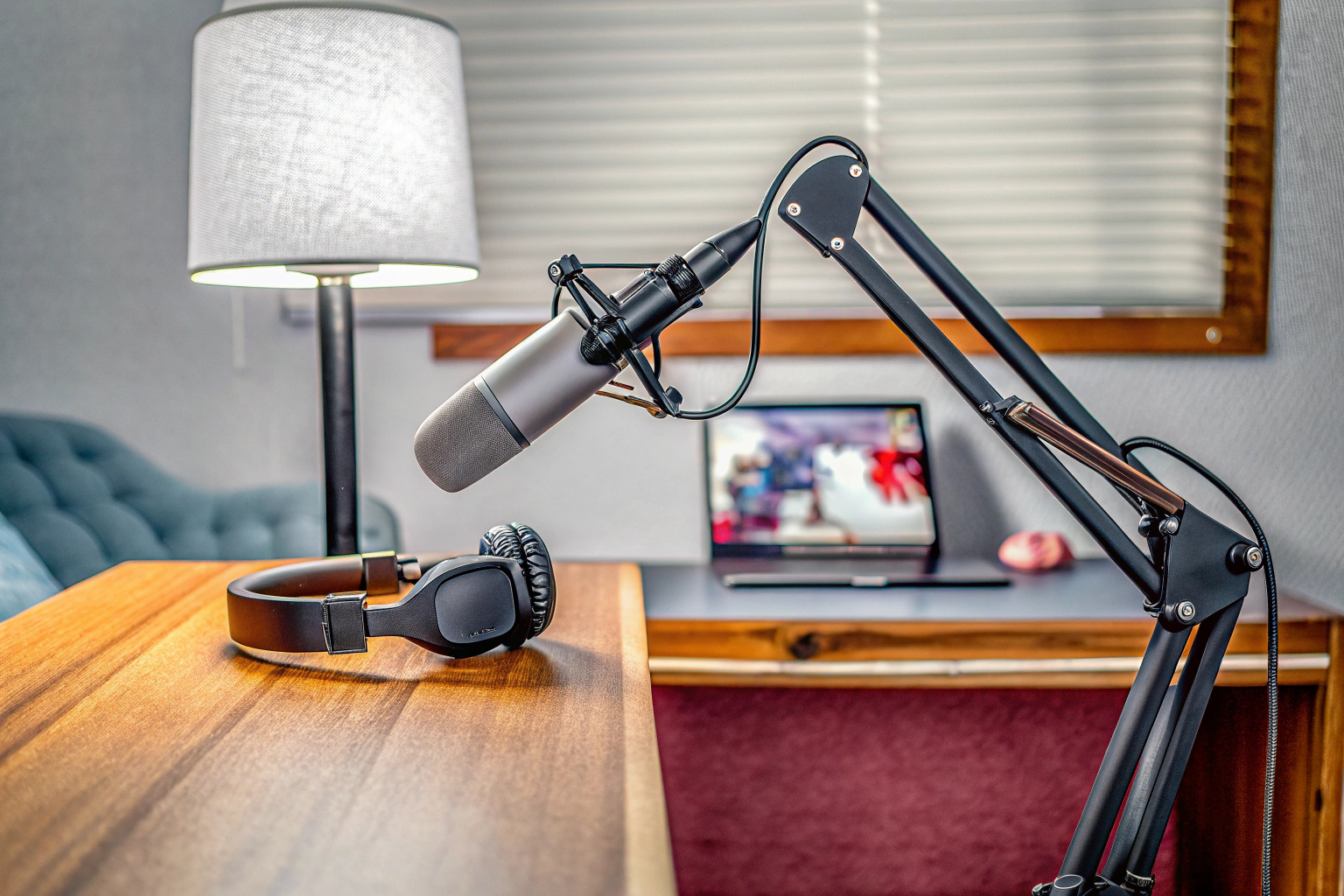 Ein moderner Podcasting-Setup mit Mikrofon, Kopfhörer und Laptop. Podcasting-Setup mit Mikrofon