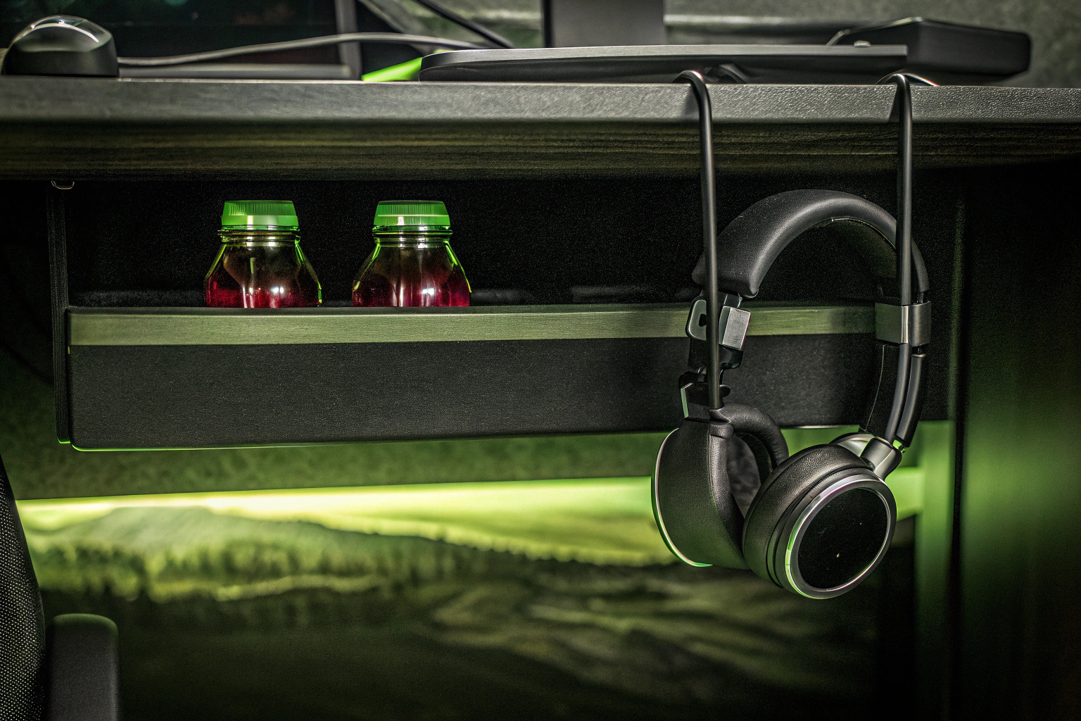 Ein multifunktionaler Getränkehalter mit Kopfhörerhaken an einem Schreibtisch montiert. Multifunktionaler Getränkehalter für Gamer