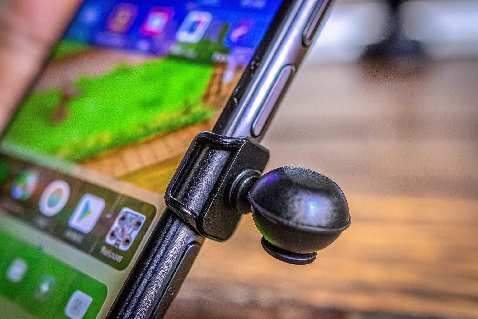 Ein Ozkak Mini Handy Joystick, der auf einem Smartphone-Display montiert ist. Ozkak Mini Handy Joystick auf Smartphone