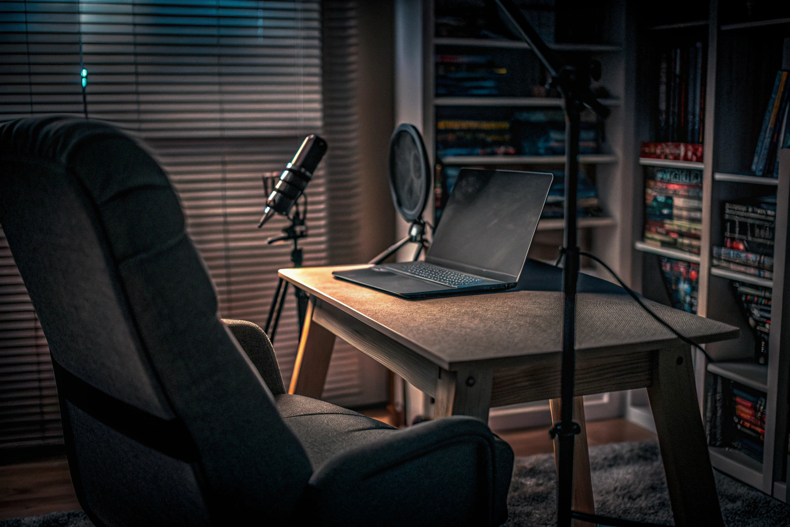 Ein Podcaster, der mit einem Laptop und einem Mikrofon in einem Heimstudio arbeitet. Podcaster im Heimstudio