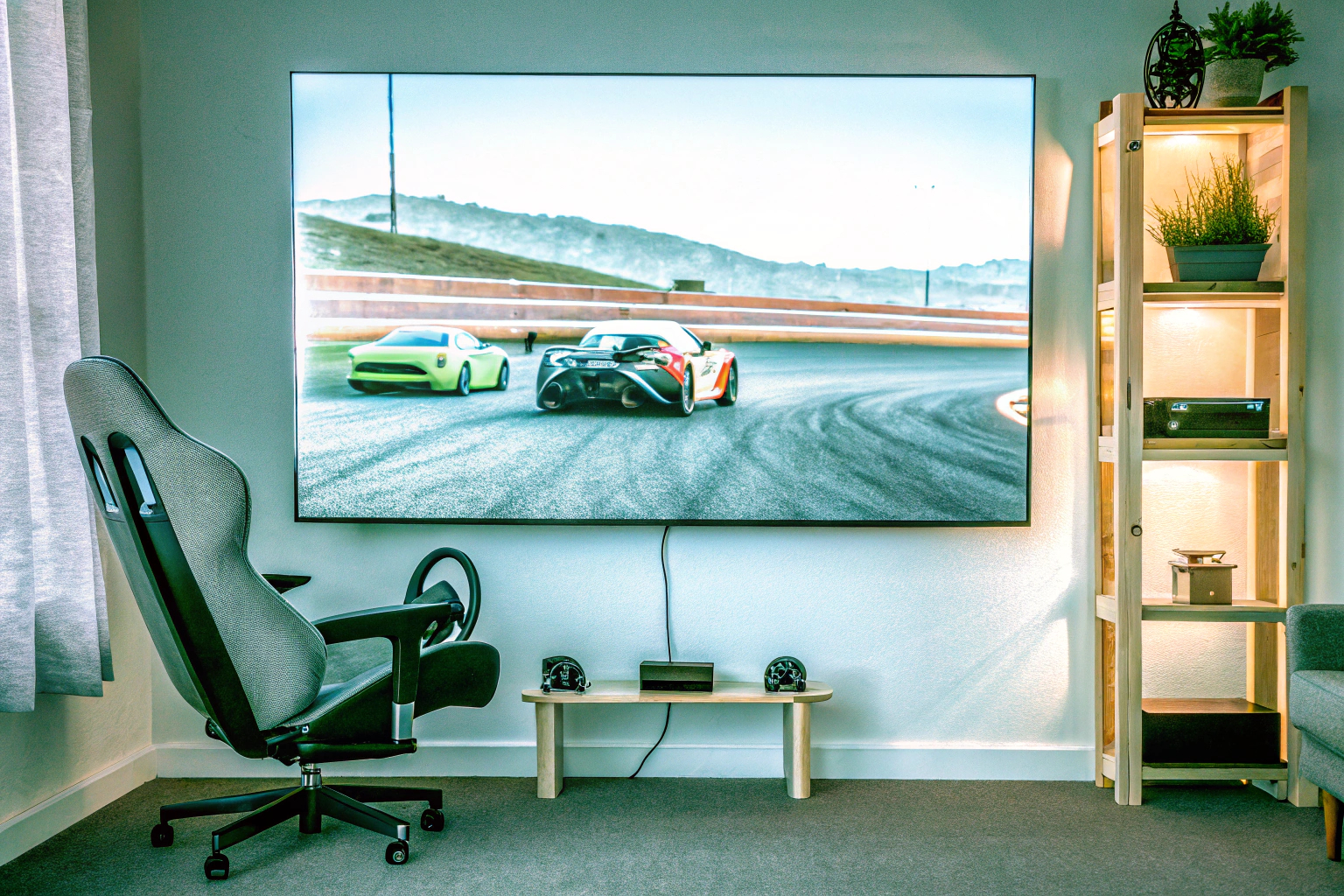 Ein Spieler, der ein Rennspiel auf einem großen Bildschirm spielt, umgeben von Rennsport-Accessoires. Rennspiel auf Bildschirm