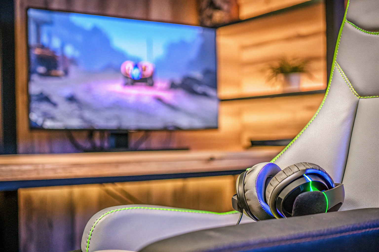 Ein Spieler, der in einem Gaming-Stuhl sitzt und ein Gaming-Headset trägt, während er auf einem Bildschirm spielt. Gamer mit Headset beim Spielen