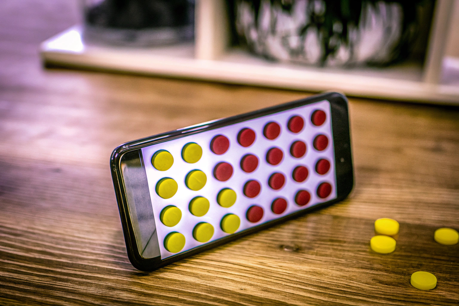 Ein Spieler genießt das klassische Strategiespiel Vier Gewinnt auf seinem Smartphone. Vier Gewinnt Strategiespiel auf dem Smartphone