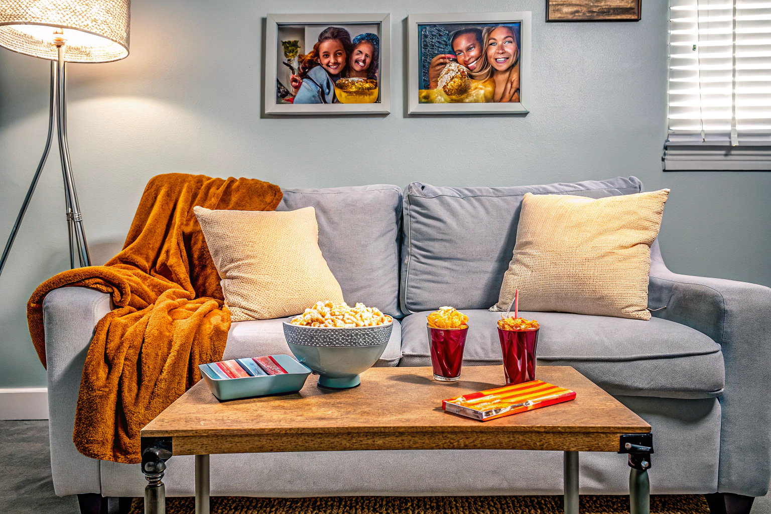 Ein Wohnzimmer mit einer gemütlichen Couch, Getränke und Snacks griffbereit, bereit für einen Spieleabend. Gemütliches Wohnzimmer für Spieleabend
