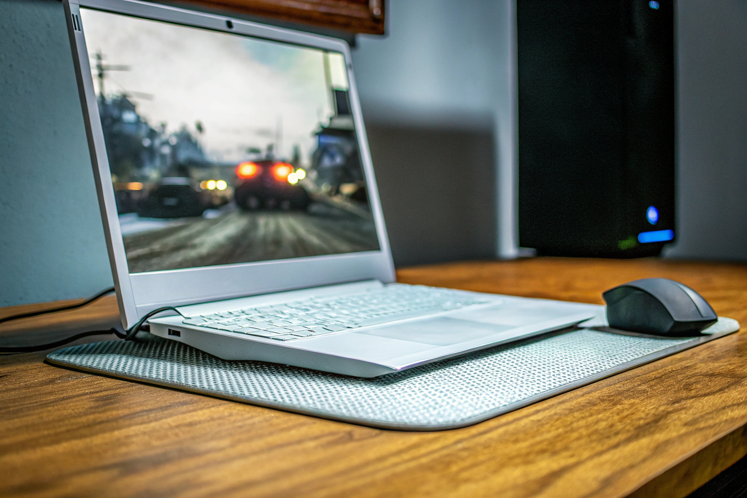 Eine Gaming-Session mit mehreren Peripheriegeräten, darunter eine Gaming-Tastatur und ein Laptop-Kühlpad. Gaming-Setup mit Tastatur und Kühlpad