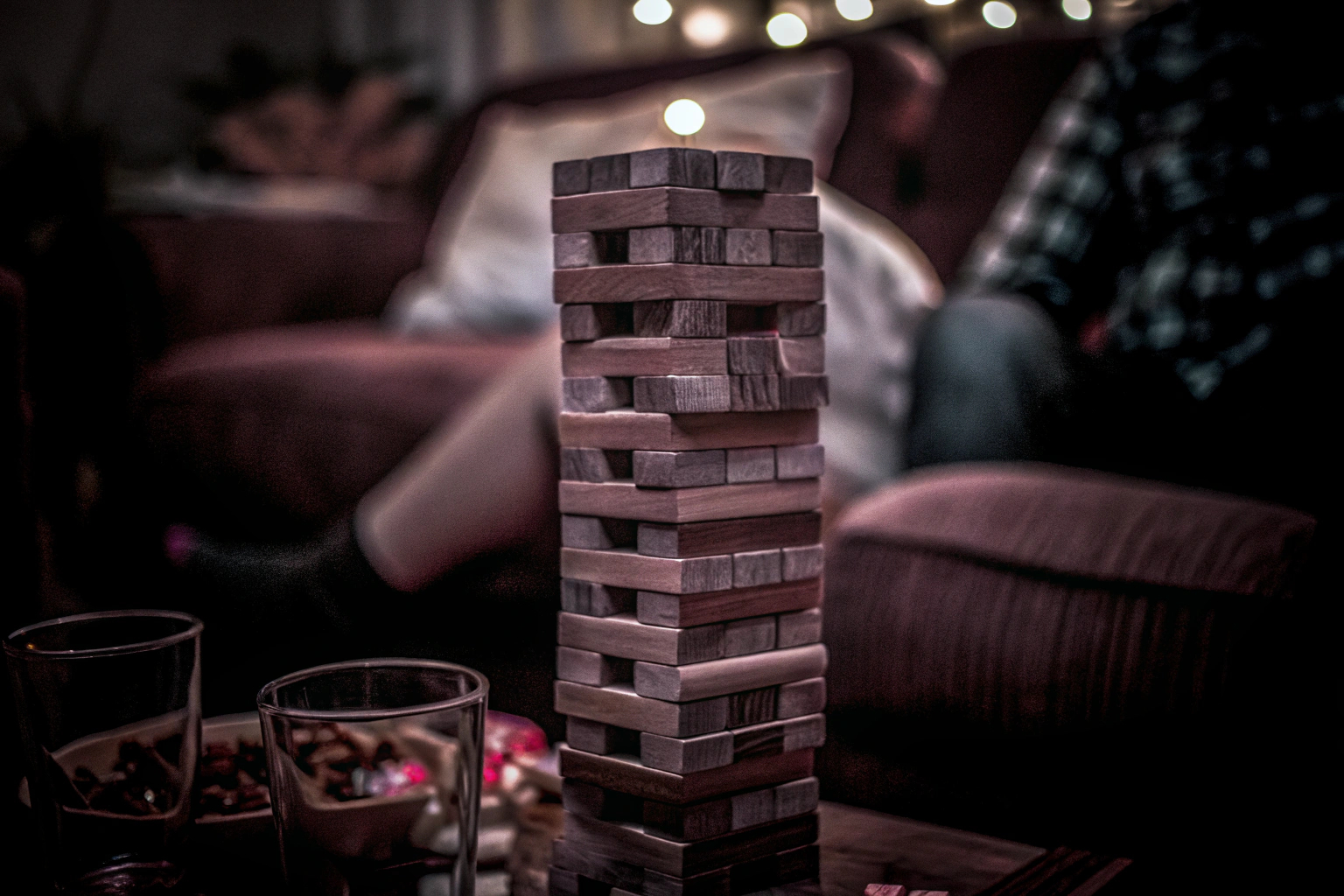 Eine Gruppe von Freunden spielt Jenga und versucht, den Turm stabil zu halten. Freunde spielen Jenga