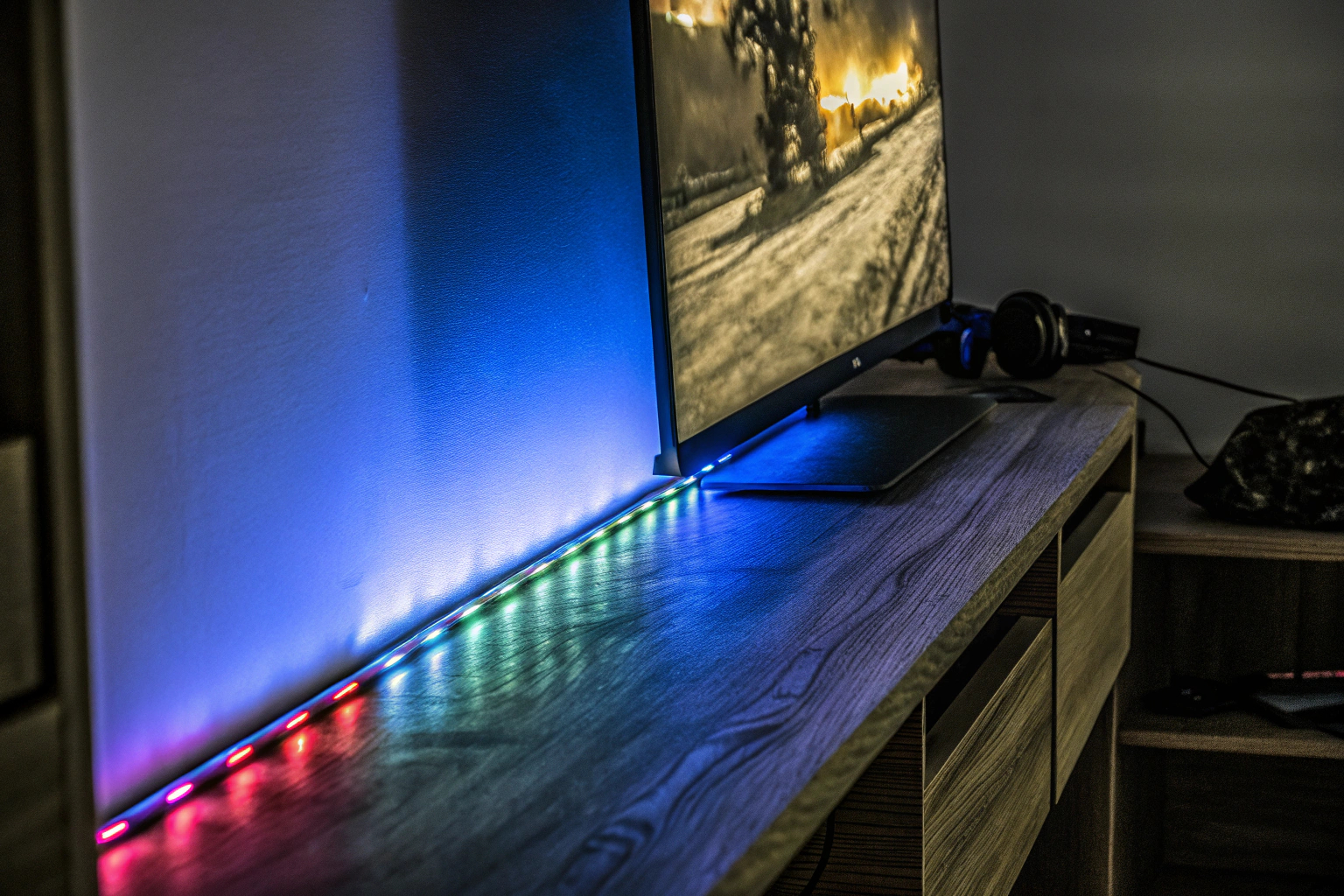 Eine RGB-Lichtleiste neben einem Monitor, die das Gaming-Setup beleuchtet. RGB-Lichtleiste bei einem Gaming-Setup