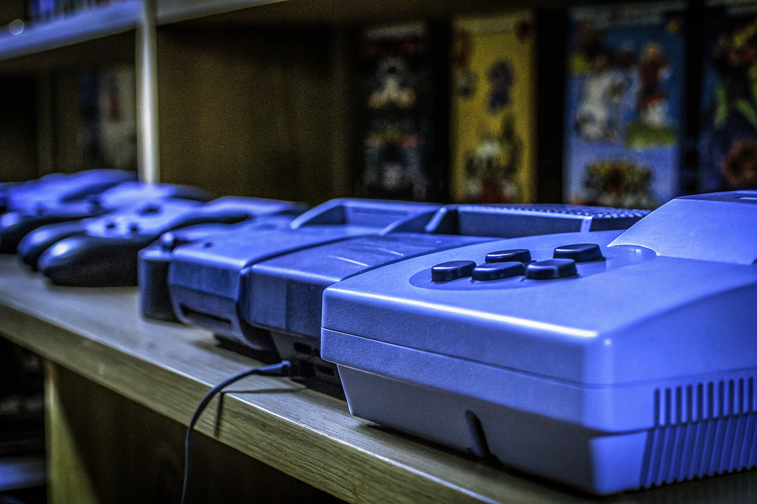 Eine Sammlung von verschiedenen Retro-Gaming-Konsolen auf einem Regal, perfekt organisiert und präsentiert. Retro-Gaming-Konsolen-Sammlung