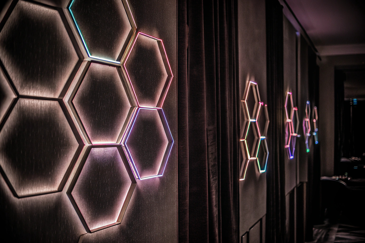 Kangtaixin LED Sechseck Wandleuchten an einer Wand, die in verschiedenen Farben leuchten und ein modernes Design bilden. Kangtaixin LED Sechseck Wandleuchten Wanddesign