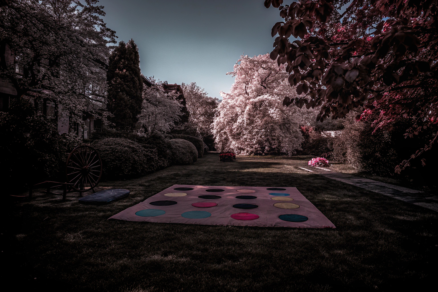 Kinder spielen das Twister Partyspiel von Hasbro Gaming im Garten. Kinder spielen Twister im Garten