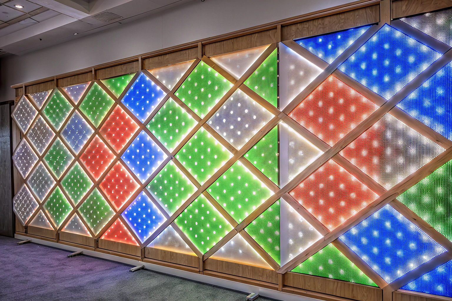 Modulare LED Panels an einer Wand montiert, die in verschiedenen Farben leuchten. LED Panels Gaming Beleuchtung