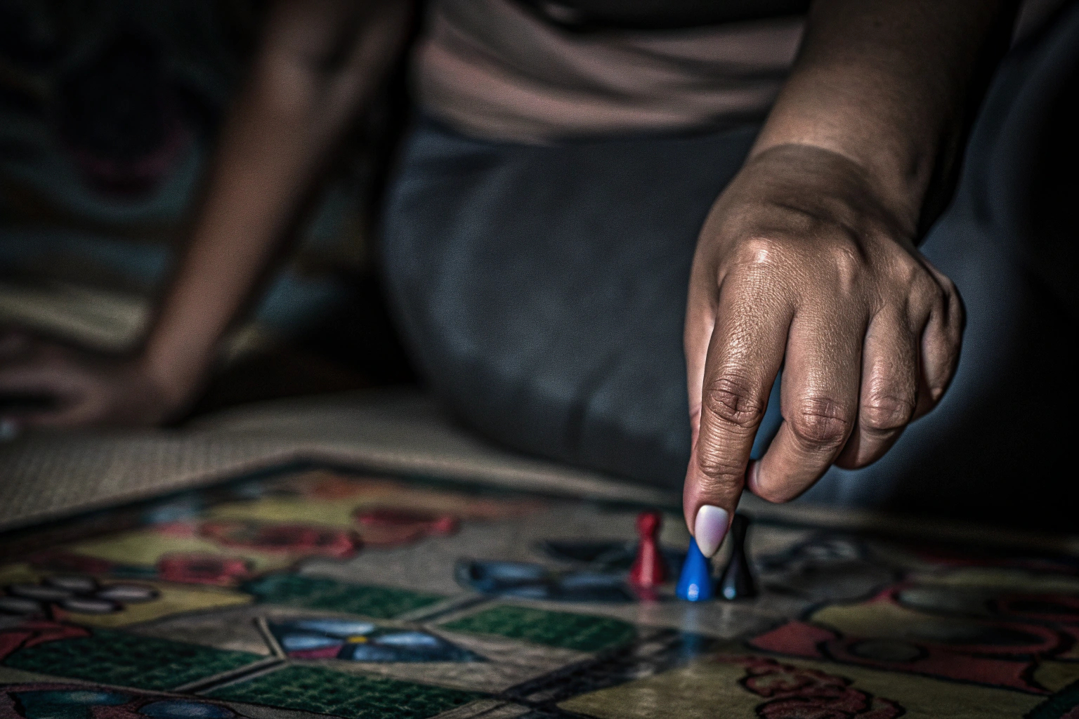 Nahaufnahme einer Hand, die eine Spielfigur auf einem Spielbrett platziert. Spielfigur auf einem Spielbrett