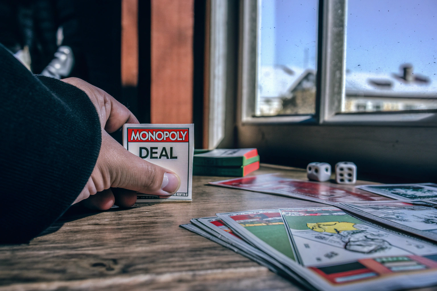 Spieler, die Karten aus dem Monopoly Deal Kartenspiel ziehen. Monopoly Deal Kartenspiel